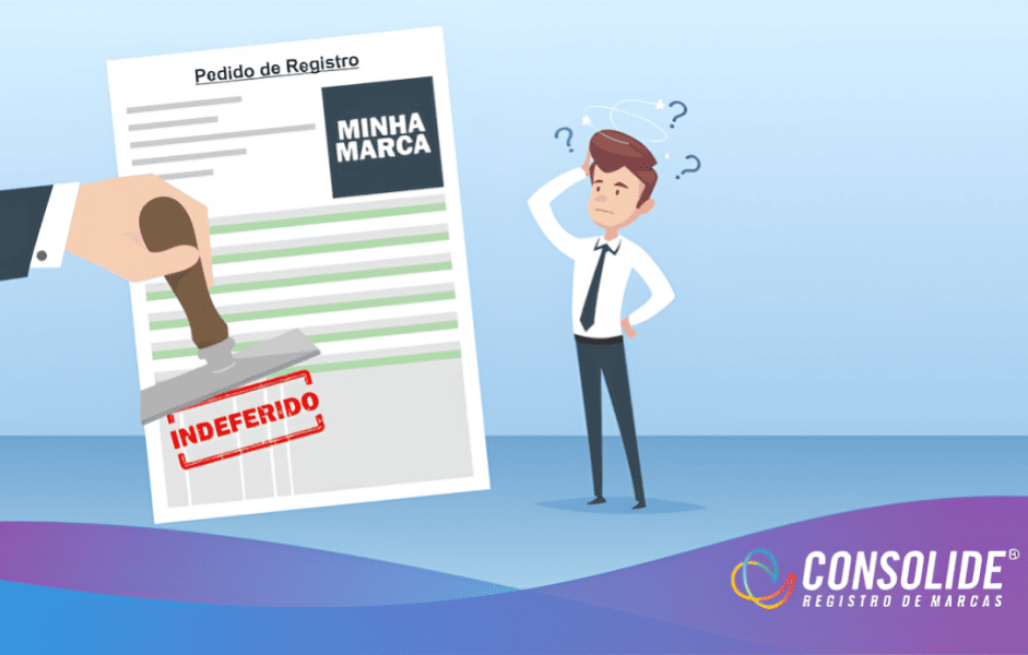 Ilustração de um pedido de registro de marca sendo carimbado como indeferido, enquanto um homem de terno observa confuso. Imagem da Consolide Registro de Marcas.